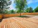 Large wooden deck and wood fence, with large shade trees surrounding the yard at 8694 E Eastman Ave, Denver, CO 80231