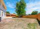 Expansive backyard with wood fence, concrete patio, and large mature shade tree at 8694 E Eastman Ave, Denver, CO 80231