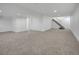 Unfurnished basement features carpeted flooring, stairs to upper level, and neutral white walls at 8694 E Eastman Ave, Denver, CO 80231