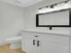 Bright bathroom featuring a white vanity, black hardware, and a framed mirror at 8694 E Eastman Ave, Denver, CO 80231