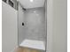 The renovated shower features a large stall with gray-patterned tile, offering a sleek, modern design at 8694 E Eastman Ave, Denver, CO 80231