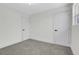 This bedroom features neutral walls, gray carpet, and two white doors at 8694 E Eastman Ave, Denver, CO 80231