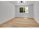 Bright bedroom with hardwood floors, modern lighting, and a large window at 8694 E Eastman Ave, Denver, CO 80231