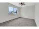 Bright bedroom with modern ceiling fan, gray carpet, and large window at 8694 E Eastman Ave, Denver, CO 80231