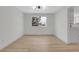 Sun-filled dining room with new hardwood floors, modern light fixture, and open layout at 8694 E Eastman Ave, Denver, CO 80231