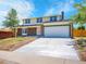 Charming two-story home featuring a brick facade, two-car garage, and a well-maintained front yard at 8694 E Eastman Ave, Denver, CO 80231