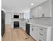 Bright kitchen showcasing white cabinets, quartz countertops, and stainless steel appliances at 8694 E Eastman Ave, Denver, CO 80231