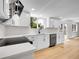 Bright kitchen features white cabinets, quartz countertops, stainless steel appliances, and wood flooring at 8694 E Eastman Ave, Denver, CO 80231