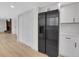 Side-by-side refrigerator in an updated kitchen with white cabinetry and light hardwood floors at 8694 E Eastman Ave, Denver, CO 80231