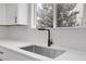 Close-up of kitchen sink with a stainless steel basin, matte black faucet, and quartz countertop at 8694 E Eastman Ave, Denver, CO 80231