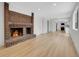 Inviting living room with a brick fireplace, new flooring and open layout to kitchen at 8694 E Eastman Ave, Denver, CO 80231