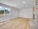 Neutral living room features wood flooring and a large window overlooking trees at 8694 E Eastman Ave, Denver, CO 80231