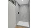 Modern shower stall with gray marble-look tile, frameless door, and black fixtures at 8694 E Eastman Ave, Denver, CO 80231