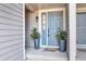The front door is light blue with decorative plants on the side and a welcome mat at 12561 E Cornell Cir, Aurora, CO 80014