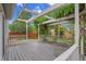 Back porch with a pergola roof, wood decking, and white railings with a fenced-in backyard in the distance at 1717 Tulip St, Longmont, CO 80501