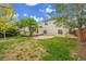 The backyard features a patio, lawn, flowering trees, landscaping, and a back porch attached to the house at 1717 Tulip St, Longmont, CO 80501