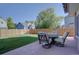 Backyard with lush grass, wood fence, and patio seating area with circular wrought iron table at 2195 S Espana St, Aurora, CO 80013