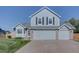 Charming two-story home with light blue siding, a well-kept lawn, and an attached two-car garage at 2195 S Espana St, Aurora, CO 80013