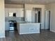 Kitchen featuring an island, stainless steel appliances, white cabinets, and hardwood floors at 7360 Watercress Dr, Littleton, CO 80125
