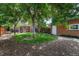 Landscaped backyard with green grass, mature trees, and a brick garage at 3779 Quitman St, Denver, CO 80212