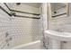 This beautiful bathroom features white subway tile with decorative accents, a tub, and a bright window at 3779 Quitman St, Denver, CO 80212