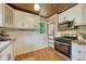 Bright kitchen features white cabinetry, modern appliances, and stylish ceiling at 3779 Quitman St, Denver, CO 80212
