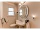 Bathroom featuring a white sink, a round framed mirror, a towel rack and natural light at 2061 E Floyd Ave, Englewood, CO 80113