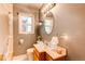 Neutral bathroom with an oval mirror, window, vanity and toilet at 2061 E Floyd Ave, Englewood, CO 80113