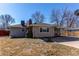 Home exterior featuring a well-maintained lawn, covered porch, and mature trees at 2061 E Floyd Ave, Englewood, CO 80113