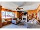 Cozy wood-paneled living room with a fireplace, comfortable seating, and natural light from a large window at 2061 E Floyd Ave, Englewood, CO 80113