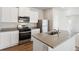 Modern kitchen featuring stainless steel appliances, quartz countertops, and an island with a sink at 2973 Oxley St, Strasburg, CO 80136