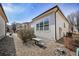 Exterior of home featuring a small patio area bordered with landscaping rock at 1481 Red Poppy Way, Brighton, CO 80601