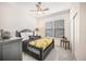 Comfortable bedroom with a ceiling fan, a bed with decorative pillows, and a view of the outside at 1481 Red Poppy Way, Brighton, CO 80601