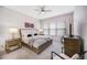 Bright bedroom with a comfortable bed, side tables, and a TV, illuminated by natural light from the large windows at 1481 Red Poppy Way, Brighton, CO 80601