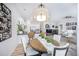 Open-concept dining area with a round table, kitchen bar, and a glimpse into the living room with a fireplace at 1481 Red Poppy Way, Brighton, CO 80601