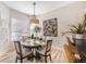 Cozy dining area featuring a round table illuminated by a modern pendant light, next to a window and stylish wall art at 1481 Red Poppy Way, Brighton, CO 80601