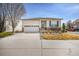 Well-maintained single-story home with stucco siding, stone accents, and attached two-car garage at 1481 Red Poppy Way, Brighton, CO 80601