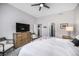 Spacious bedroom with neutral tones, featuring a large TV, dresser, and access to the ensuite bathroom and walk-in closet at 1481 Red Poppy Way, Brighton, CO 80601