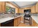 Modern kitchen featuring stainless steel oven and natural wood cabinets at 12408 E Ohio Ave, Aurora, CO 80012