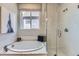 Bright bathroom with a soaking tub, glass-enclosed shower, and large window for natural light at 13812 Honey Hush Trl, Parker, CO 80134