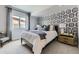 Well-lit bedroom with cozy carpeting, designer wallpaper, and a black framed bed at 13812 Honey Hush Trl, Parker, CO 80134