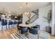 Stylish dining area with seating and modern pendant lighting, flowing into a well-equipped kitchen and staircase at 13812 Honey Hush Trl, Parker, CO 80134
