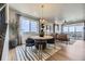 Dining area with modern round table and chairs, open to the spacious living room and bright windows at 13812 Honey Hush Trl, Parker, CO 80134