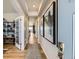 Bright hallway showcasing modern lighting, hardwood floors, elegant artwork, and an open view into other living spaces at 13812 Honey Hush Trl, Parker, CO 80134