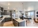 Open-concept kitchen featuring a center island, stainless steel appliances, and seamless integration with the dining area at 13812 Honey Hush Trl, Parker, CO 80134