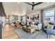 Spacious living room with hardwood floors, comfortable seating, lots of natural light, and staircase in background at 13812 Honey Hush Trl, Parker, CO 80134