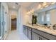 Elegant main bathroom with double vanity sinks, granite countertops, a glass-enclosed shower, and a walk-in closet at 13812 Honey Hush Trl, Parker, CO 80134