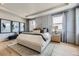 Bright main bedroom with a plush king bed, decorative pillows, large windows, and stylish wall art at 13812 Honey Hush Trl, Parker, CO 80134
