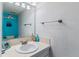 Bright bathroom featuring a white sink, neutral tile countertop and blue accent wall at 4231 S Fairplay Cir # E, Aurora, CO 80014