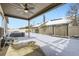 Covered patio overlooks a fenced backyard with a snowy ground at 5232 Truckee St, Denver, CO 80249